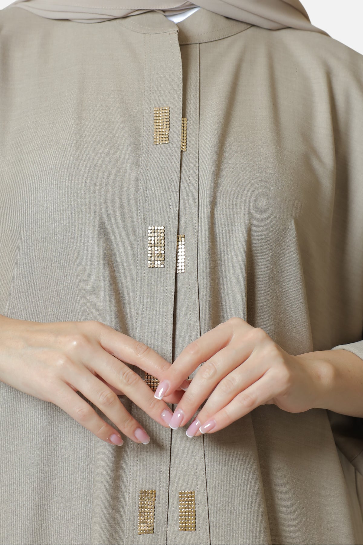 Beige cotton abaya — gold-tone front detail close-up