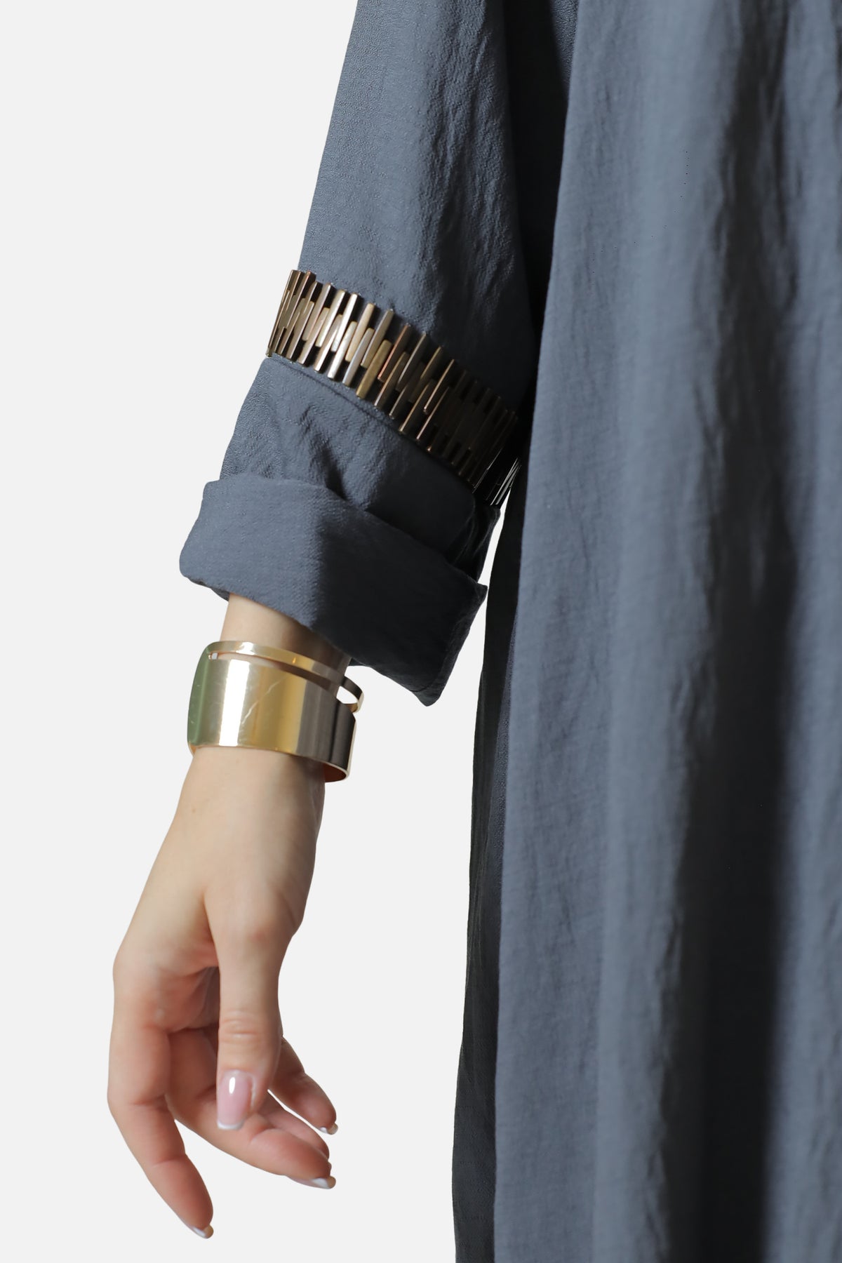 Detail of the gold-tone rectangular trim above the gray abaya cuff.