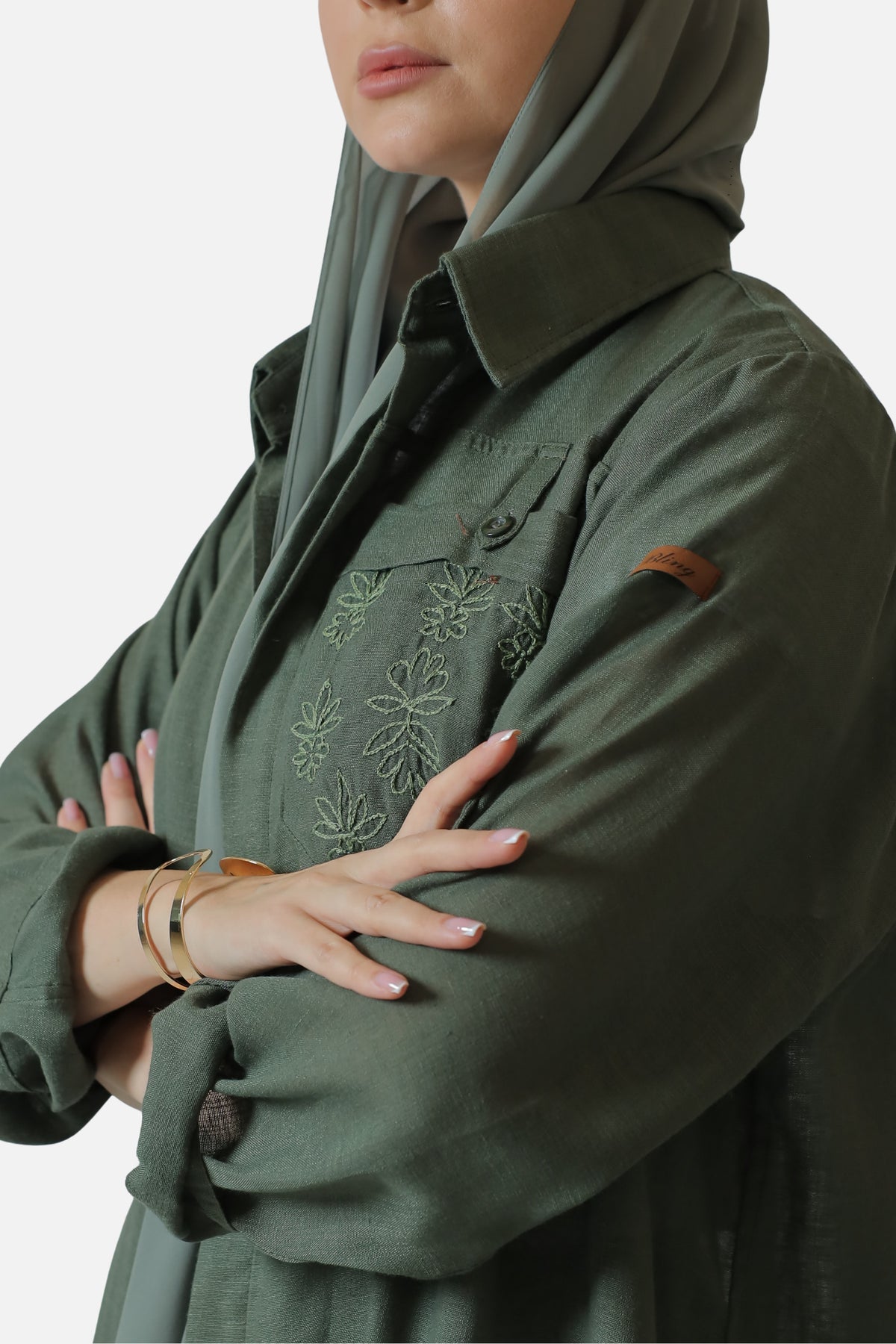 Green linen abaya — collar and tonal chest embroidery detail