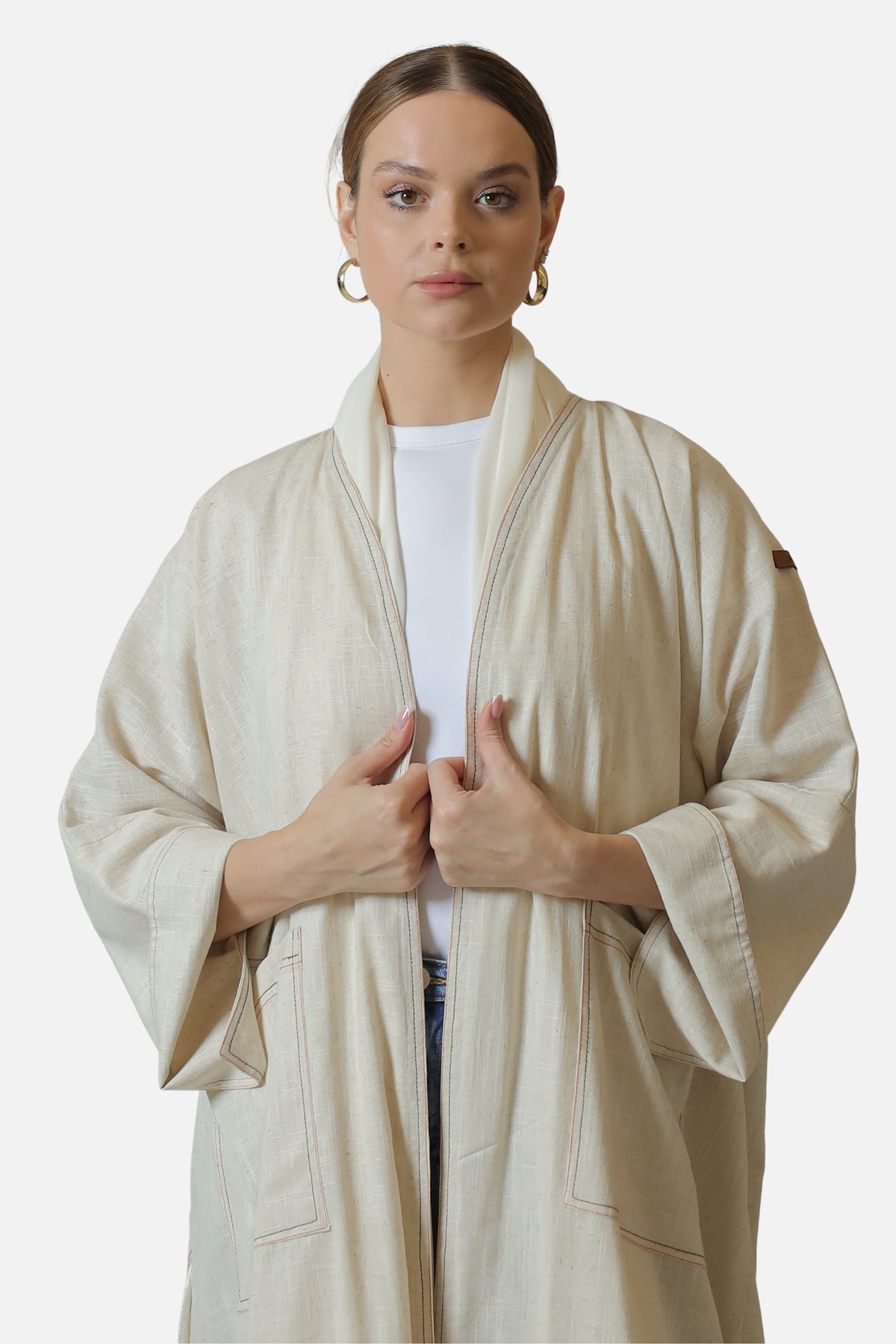Ivory linen abaya with contrast stitch details — front view with wide sleeves