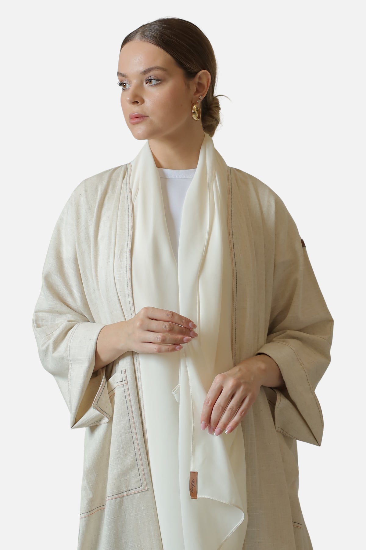 Ivory linen abaya with contrast stitch details — front detail with shaila
