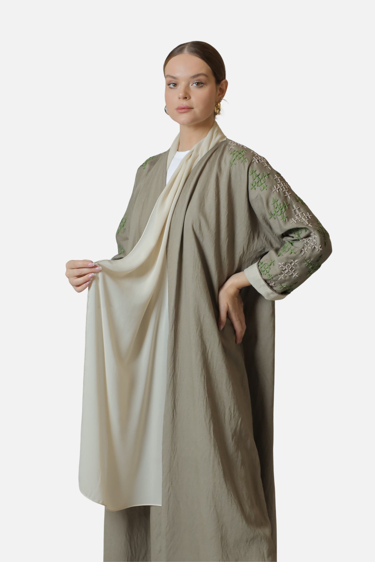 Model holding the shaila beside the beige linen abaya, showing the embroidered sleeve.