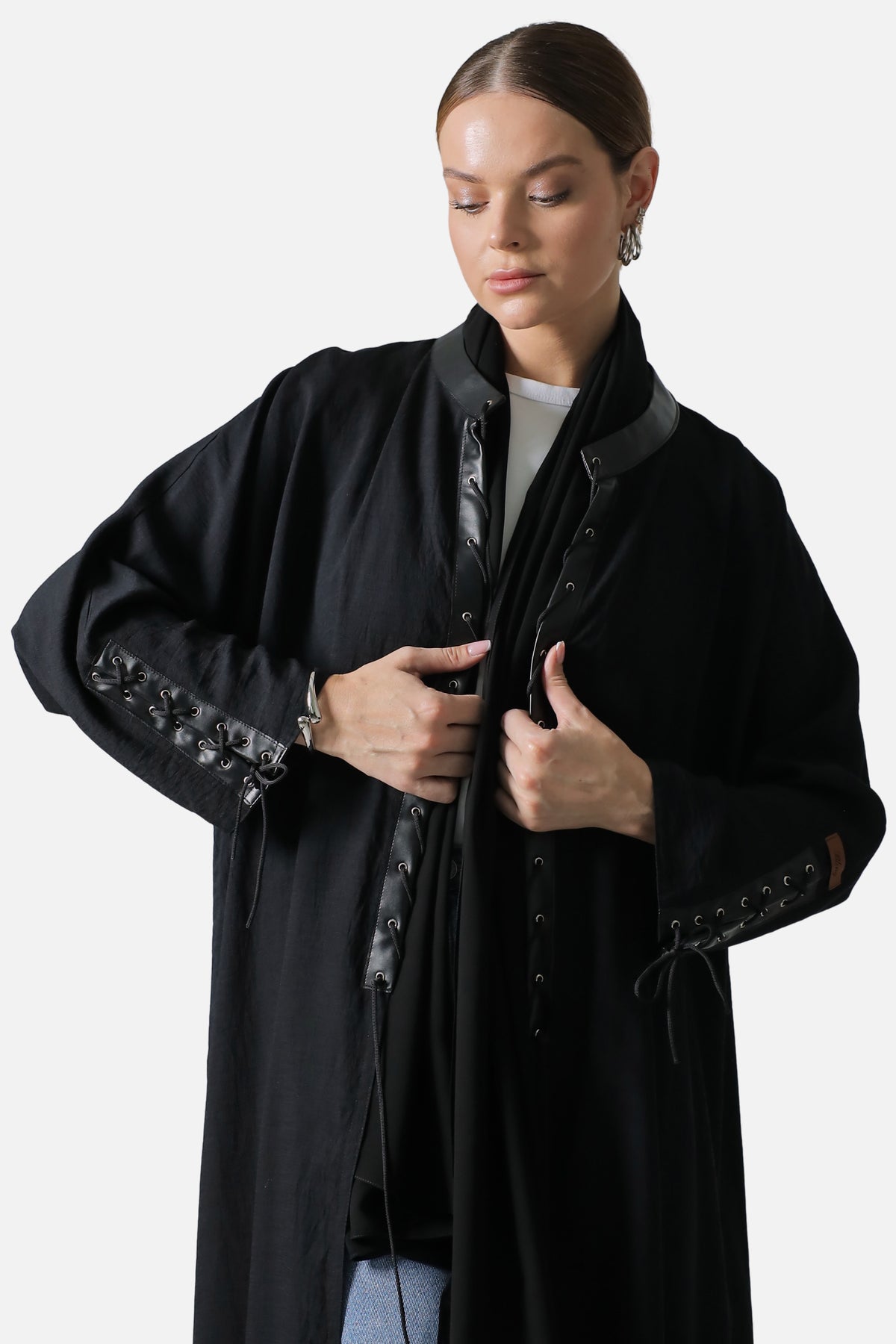 Black linen abaya worn open, leather collar and lace-up sleeve detail, three-quarter view