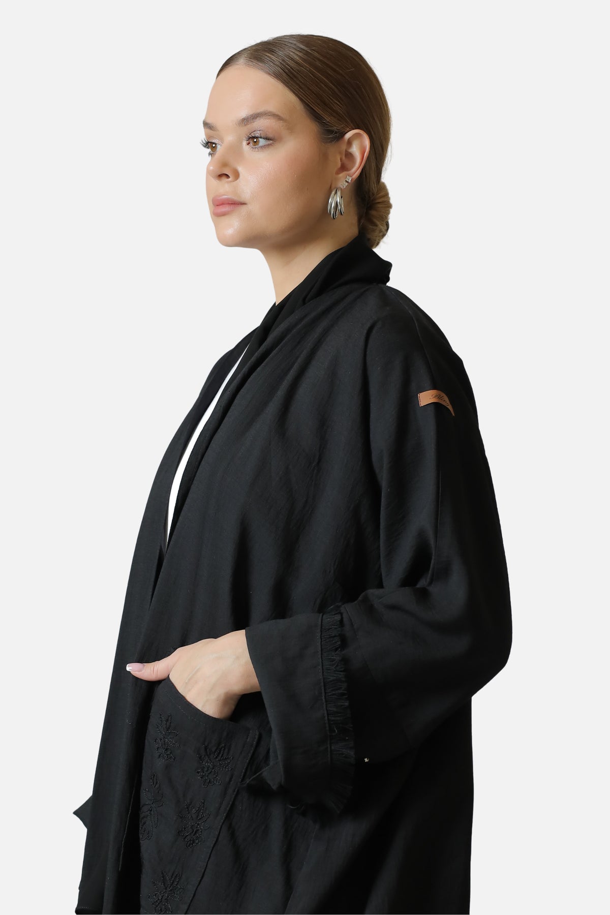 Black linen abaya, three-quarter view showing the collar and shoulder detailing