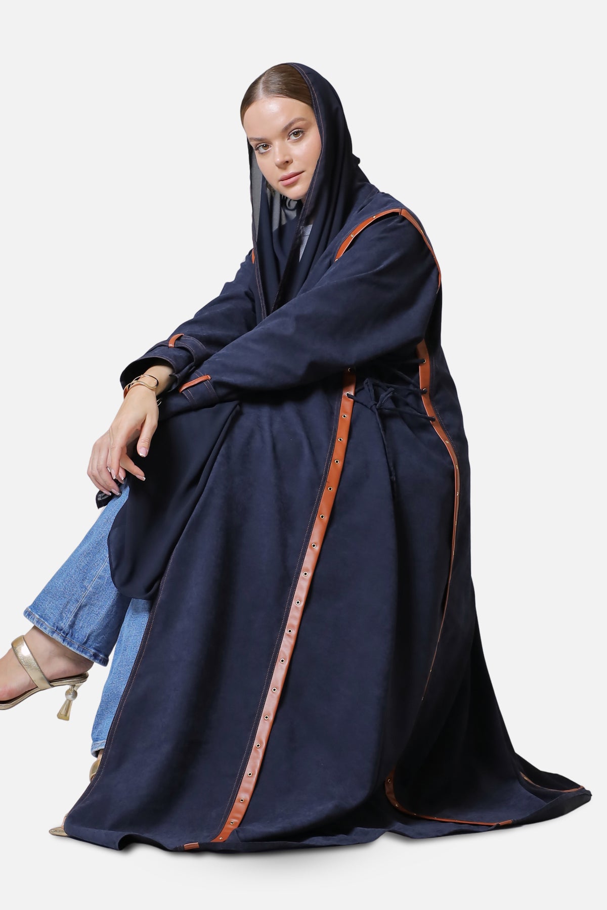 Dark blue suede abaya with leather-trimmed edges, full-length seated view