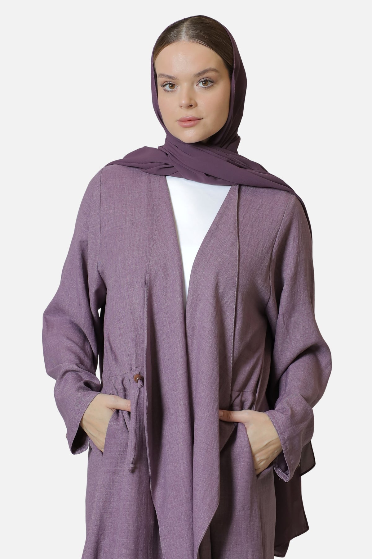 Front portrait of the purple cotton abaya with shaila and hands in the side pockets.