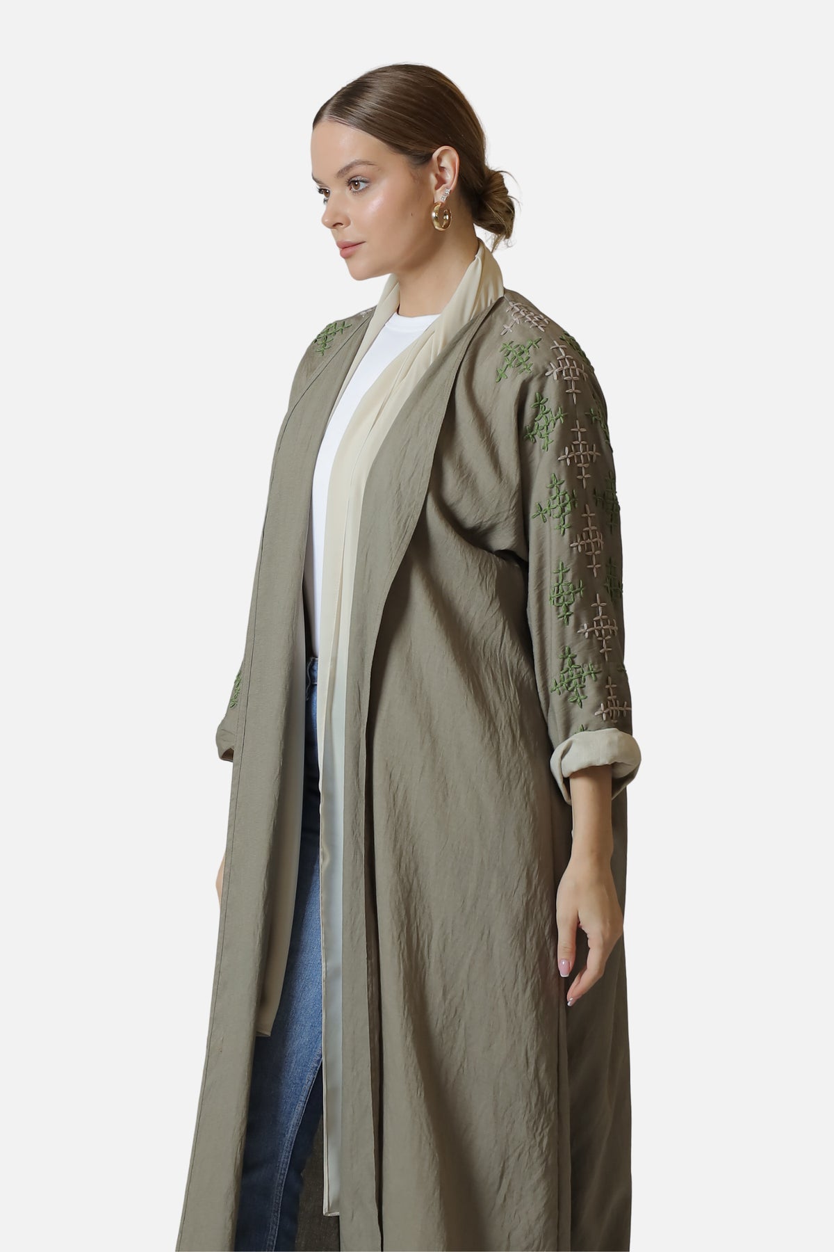 Side view of the beige linen abaya showing the embroidered sleeve and contrasting cuff.
