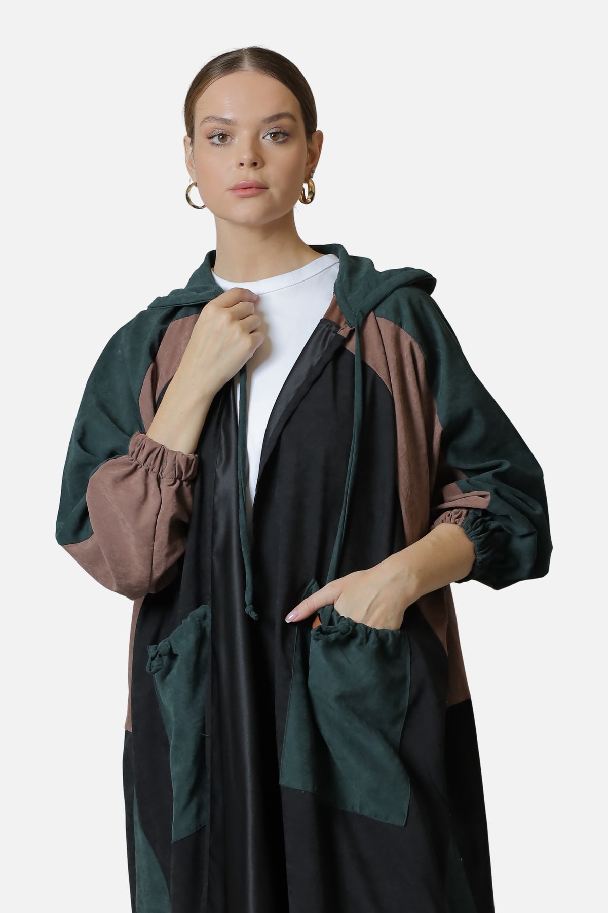 Front view of the dark green suede abaya showing the contrasting panels and front pockets.
