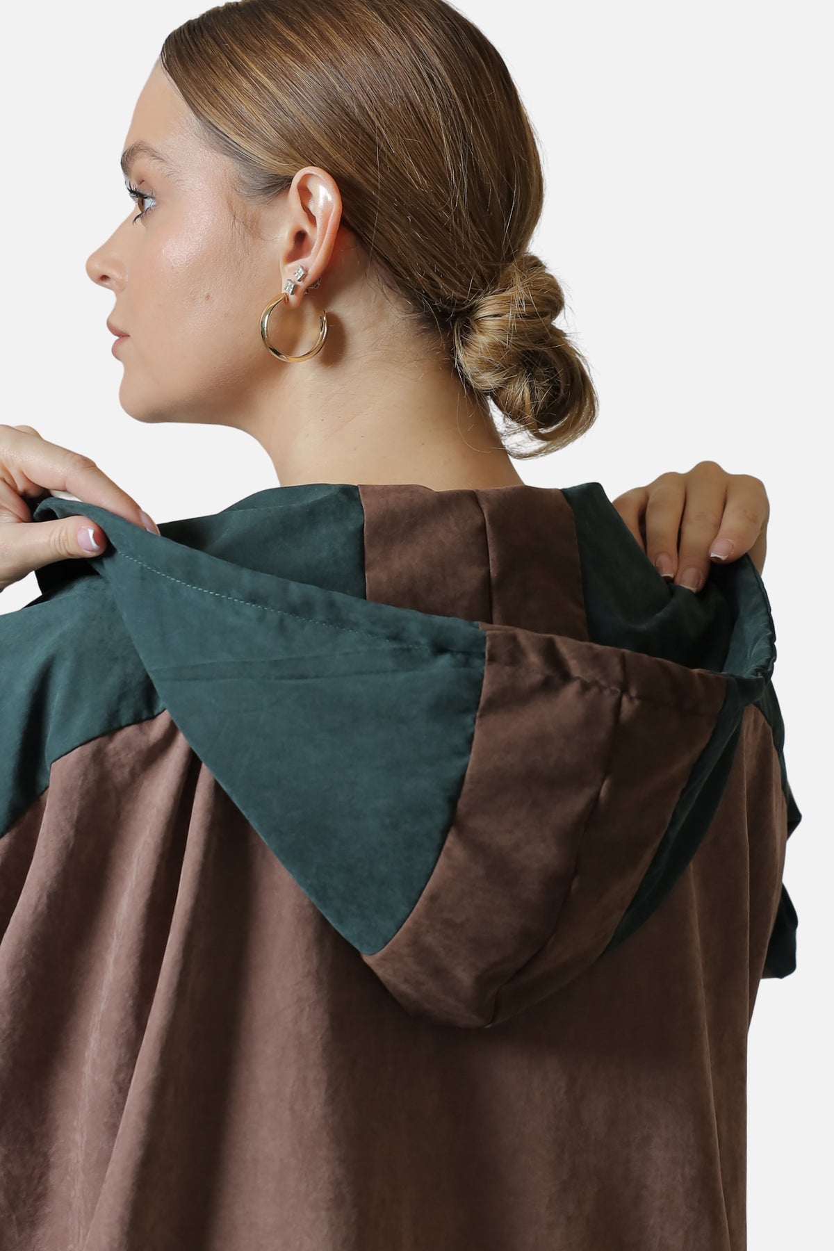 Detail of the hood on the dark green suede abaya, showing the contrasting brown and green panels.