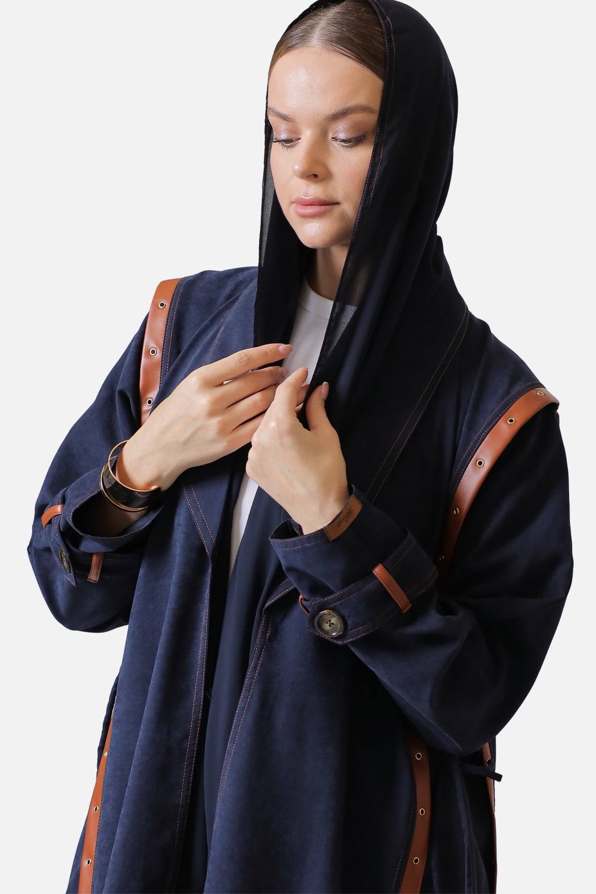 Dark blue suede abaya worn open, leather trim along the front edges and sleeve cuff