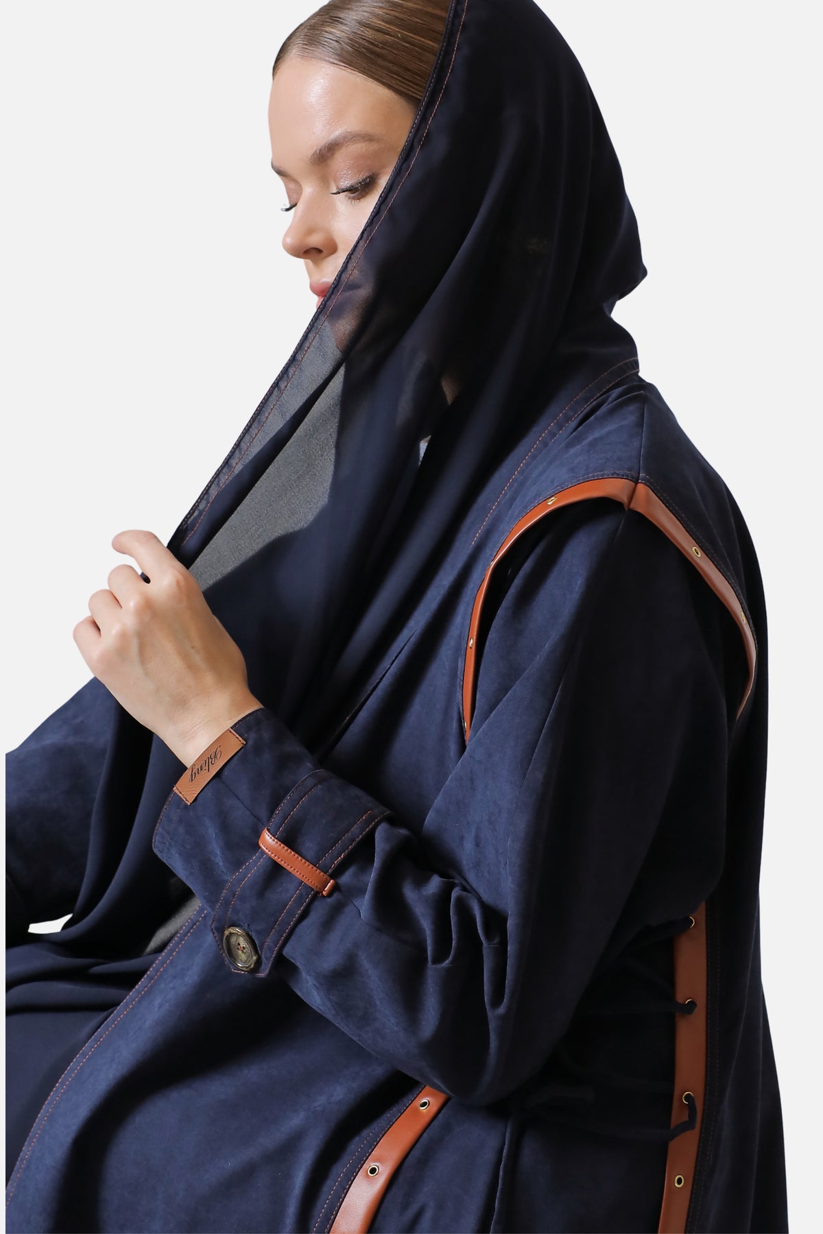 Dark blue suede abaya, side view showing the leather trim across the shoulder and sleeve
